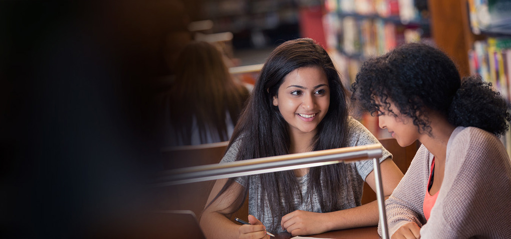 Two women talking in the library