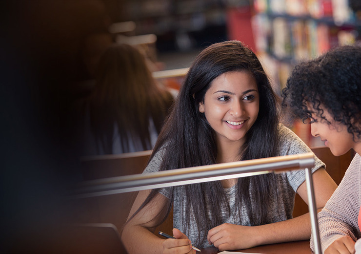 Two women talking in the library
