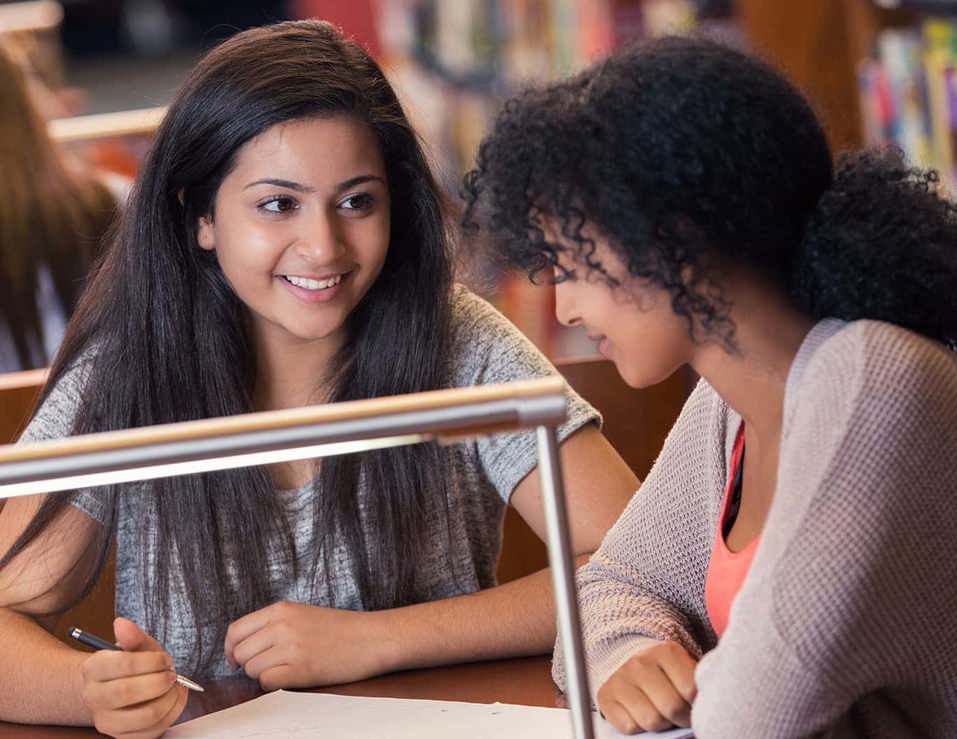 Two AMEP students talking in library